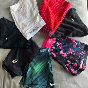 SEVEN pairs of volleyball shorts, size S and Med. NIKE, Under Armor, and ASICS.